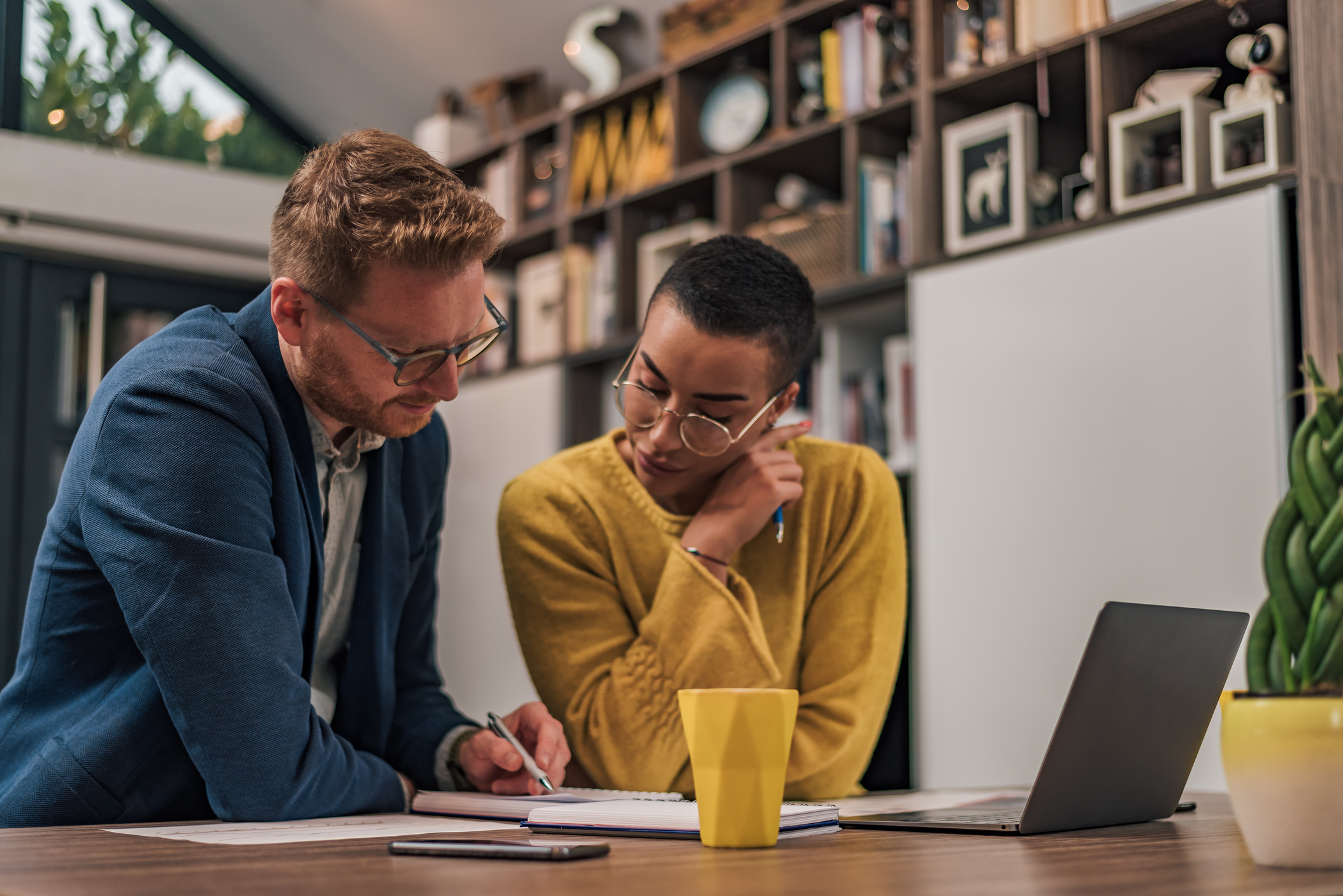 Trabajo en equipo, diversidad y gerente de ventas planificando ideas de marca con un diseñador creativo en una computadora portátil en una oficina. Logotipo, colaboración y empresario hablando con un empleado sobre un proyecto de desarrollo - Foto de stock de Ordenador libre de derechos